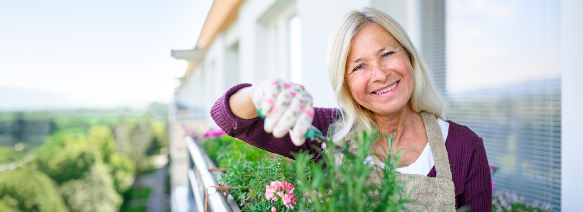 Adobe Stock | Halfpoint Weibliche Person gärtnert auf dem Balkon