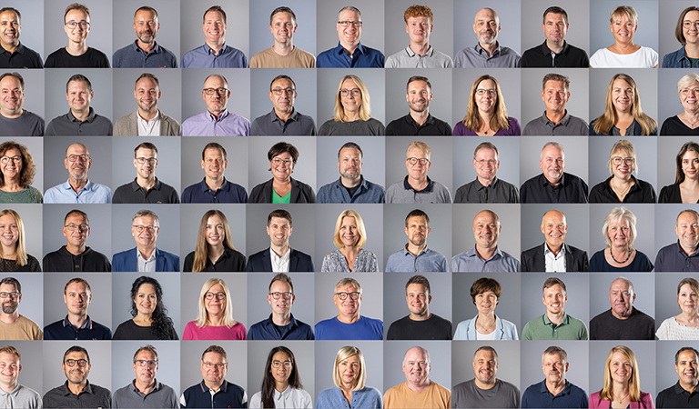 Collage aus vielen einzelnen Porträtfotos von Mitarbeitenden der WBG Lünen. Die Personen sind frontal vor neutralem grauem Hintergrund fotografiert und in mehreren Reihen übersichtlich angeordnet.